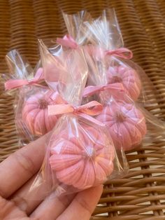 small pink cookies wrapped in cellophane and sitting on a wicker table