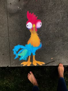 a person standing next to a chalk drawing of a rooster