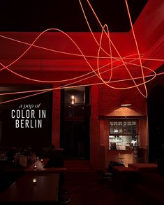 the interior of a restaurant lit up with red lights and streamers in front of it