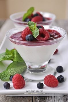 berries and yogurt are garnished with mint leaves