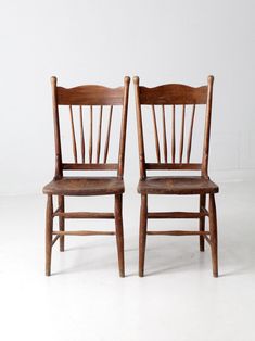 two wooden chairs sitting next to each other