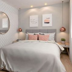 a bedroom with a bed, mirror and two lamps on the side of the wall