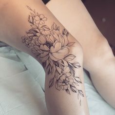 a woman's leg with flowers on it, and the bottom part of her arm