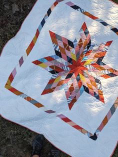 a person standing next to a quilt on the ground