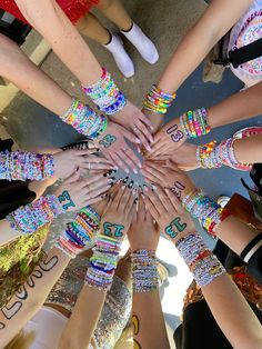 a group of people standing in a circle with their hands on top of each other