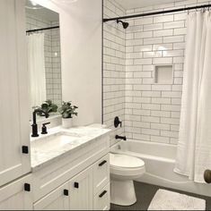 a white bathroom with black and white accessories