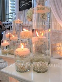 there are many vases with candles in them