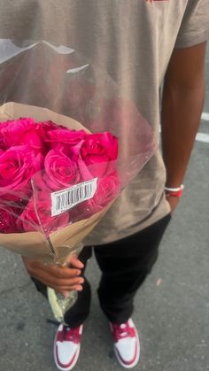 a person holding a bouquet of pink roses