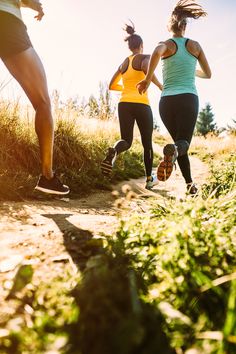 three women running on a trail in the sun