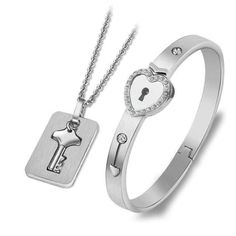 two pieces of jewelry with a heart and key on it, one is in the shape of a lock