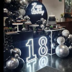 an image of a birthday party setting with balloons and cake on the table in front of it