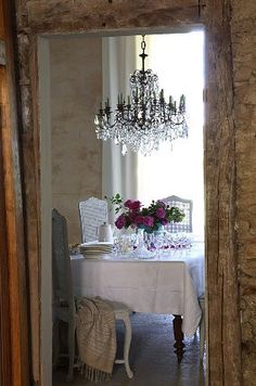 a dining room table with a chandelier hanging from it's centerpiece