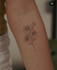 a woman's arm with a flower tattoo on the left side of her arm