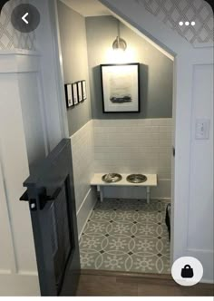 a bathroom with a dog bowl in the corner and a painting on the wall above it