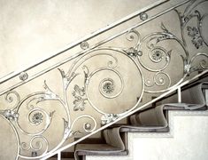 an iron stair railing with flowers and leaves painted on it's sides, along with handrails