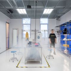 a man is standing in the middle of a room with blue and yellow furniture on display