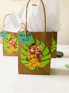 two brown bags with animals on them and thank you tags hanging from the handles, sitting on a table