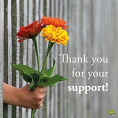 a person holding flowers in front of a fence with the words god loves you so much