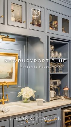 a kitchen with blue cabinets and white flowers in vases on the sink countertop