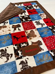 a quilted blanket with horses on it and name written in red, white, and blue