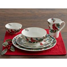 a red place mat topped with two cups and saucers on top of a wooden table