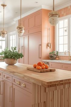 a kitchen filled with lots of pink cabinets and wooden counter top next to a sink