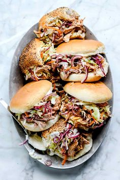 three pulled pork sandwiches on buns with coleslaw slaw and sesame seeds