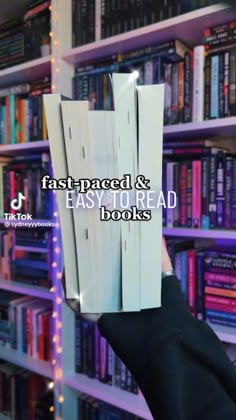 someone holding up a stack of books in front of a bookcase with the words fastpaged and easy to read books