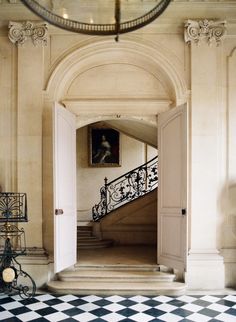 an open door leading to a staircase with a painting hanging on the wall above it