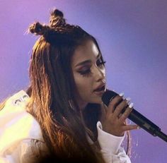 a woman with long hair holding a microphone