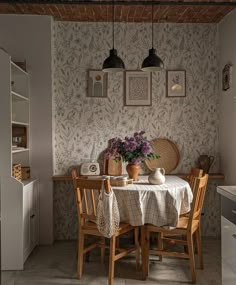 a dining room table with two chairs and a potted plant on top of it