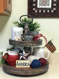 a three tiered tray with coffee mugs and other items