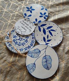 four blue and white plates sitting on top of a cloth covered tablecloth with writing