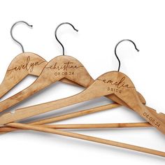 three wooden clothes hangers with names on them