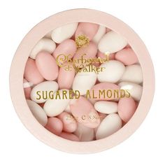 pink and white candies in a bowl with the words sugared almonds on it