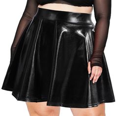 a woman wearing a black leather skirt and sheer - knit crop top with her hands on her hips