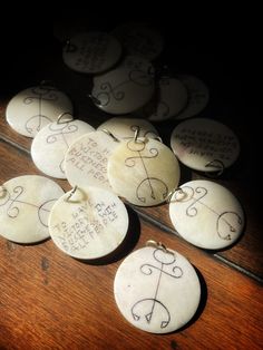 some white buttons with writing on them sitting on top of a wooden table in the dark