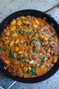 a skillet filled with food sitting on top of a table