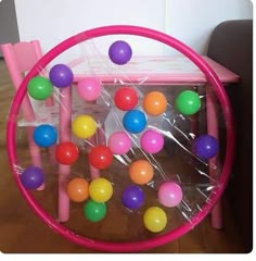 a pink plastic chair with colorful balls in it