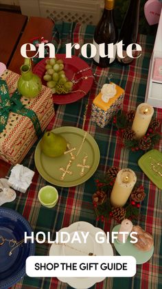 the table is set with holiday gifts and plates