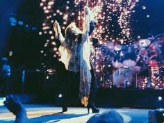 a man standing on top of a stage with his arms in the air