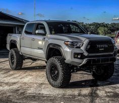 a silver toyota truck parked in front of a house