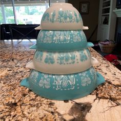 a stack of blue and white dishes sitting on top of a kitchen counter next to a window