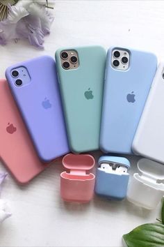 six iphone cases sitting next to each other on top of a white table with flowers in the background