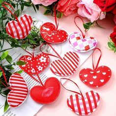 valentine's day decorations are laid out on a table with flowers in the background