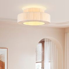 a living room with white furniture and a round light fixture