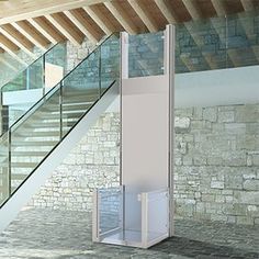 a white toilet sitting on top of a stone floor next to a banister and stairs