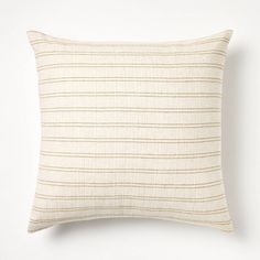 a white and beige striped pillow sitting on top of a table