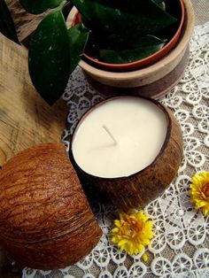 a candle and some flowers on a lace doily next to a potted plant