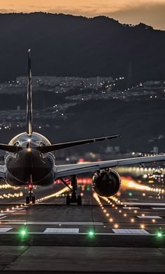 an airplane is taking off from the airport runway at night with its lights on and it's landing gear down